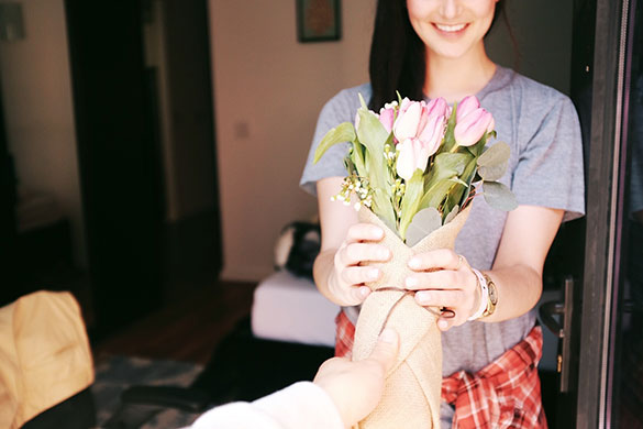 Someone giving a lady flowers